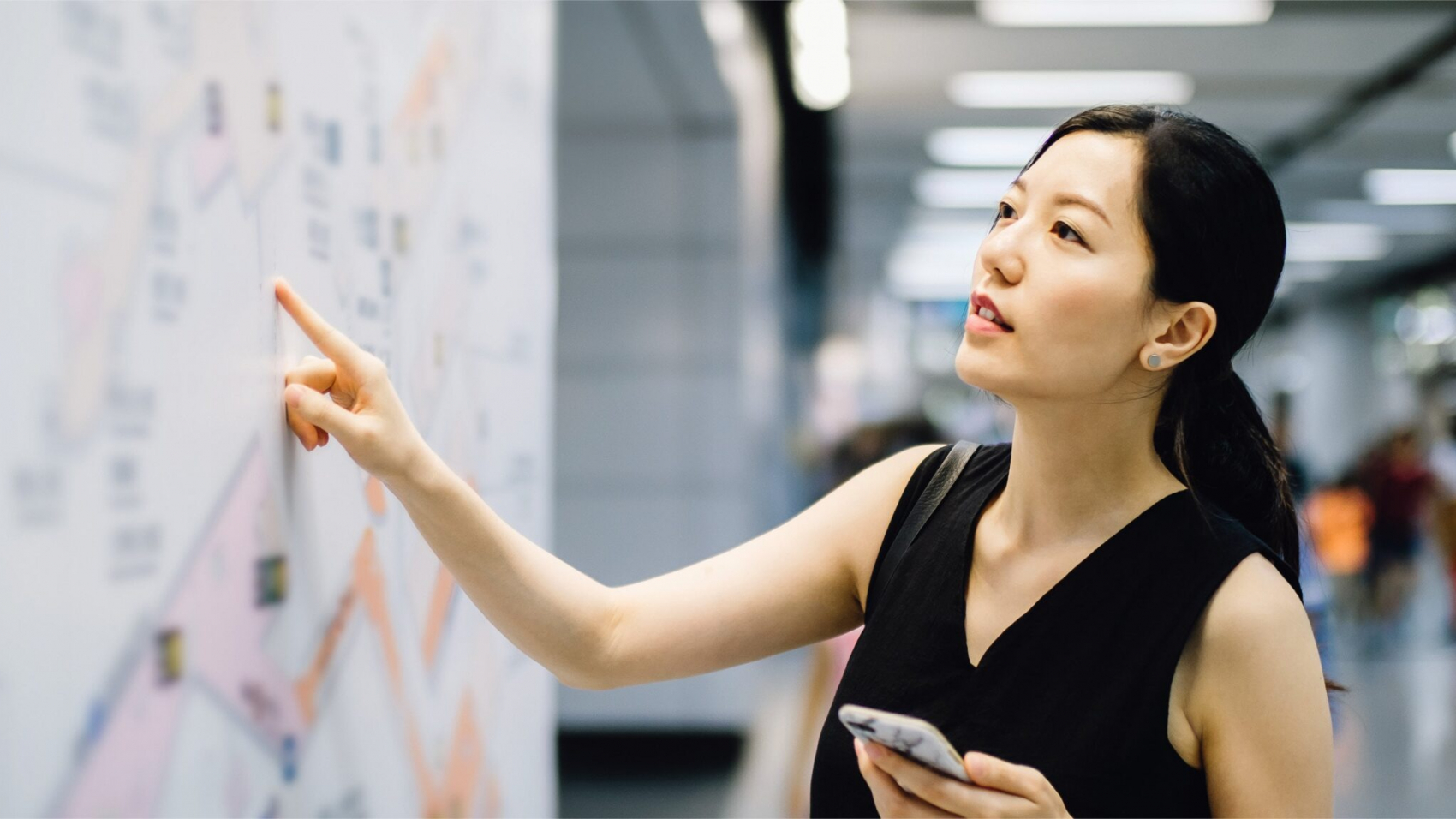 a woman pointing at a white board