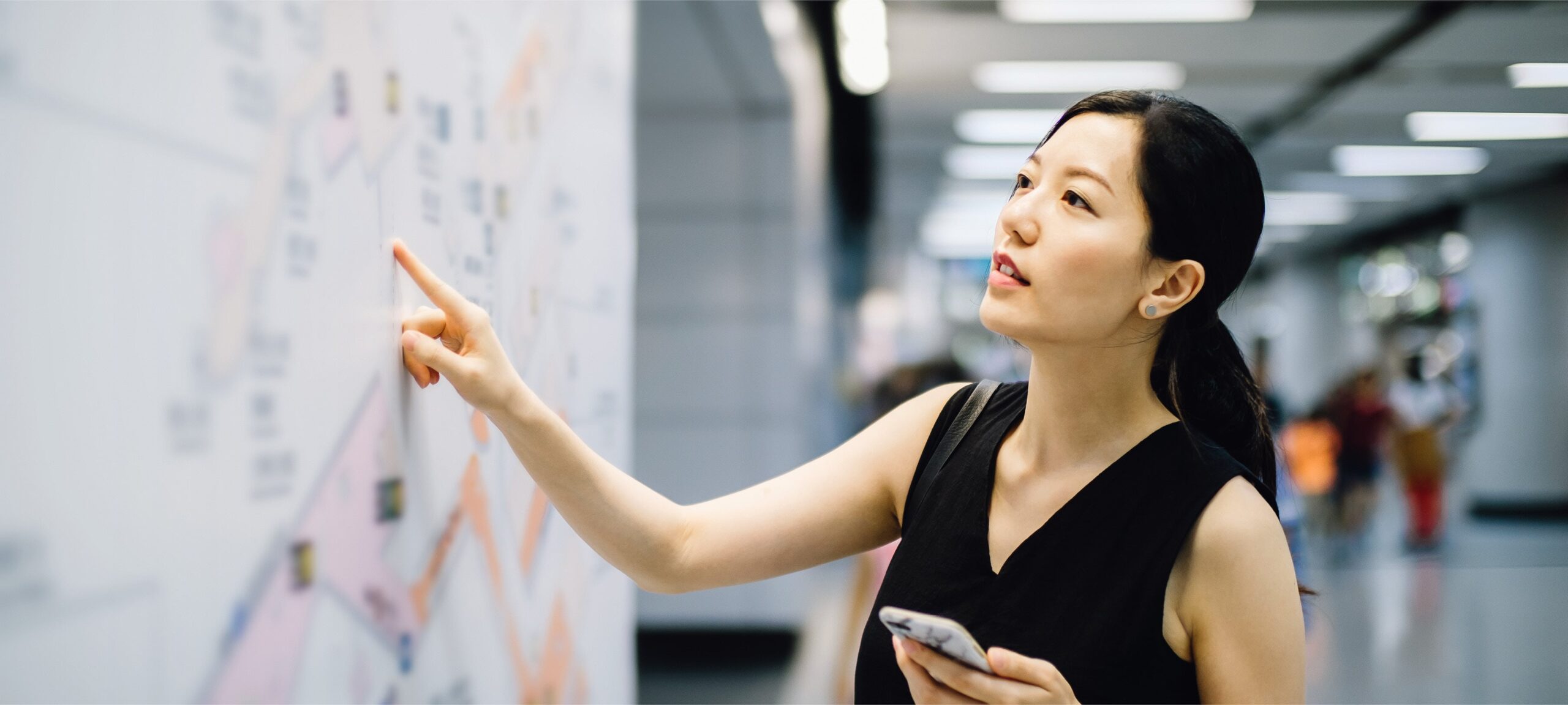 a woman pointing at a white board