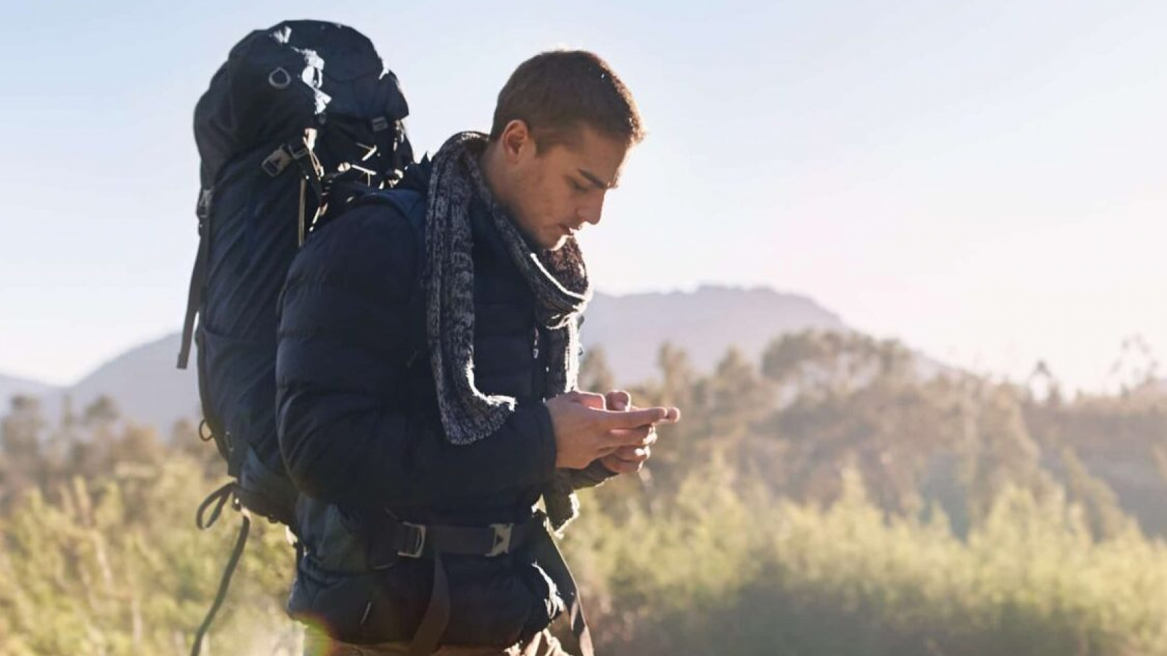 a man with a backpack looking at his phone