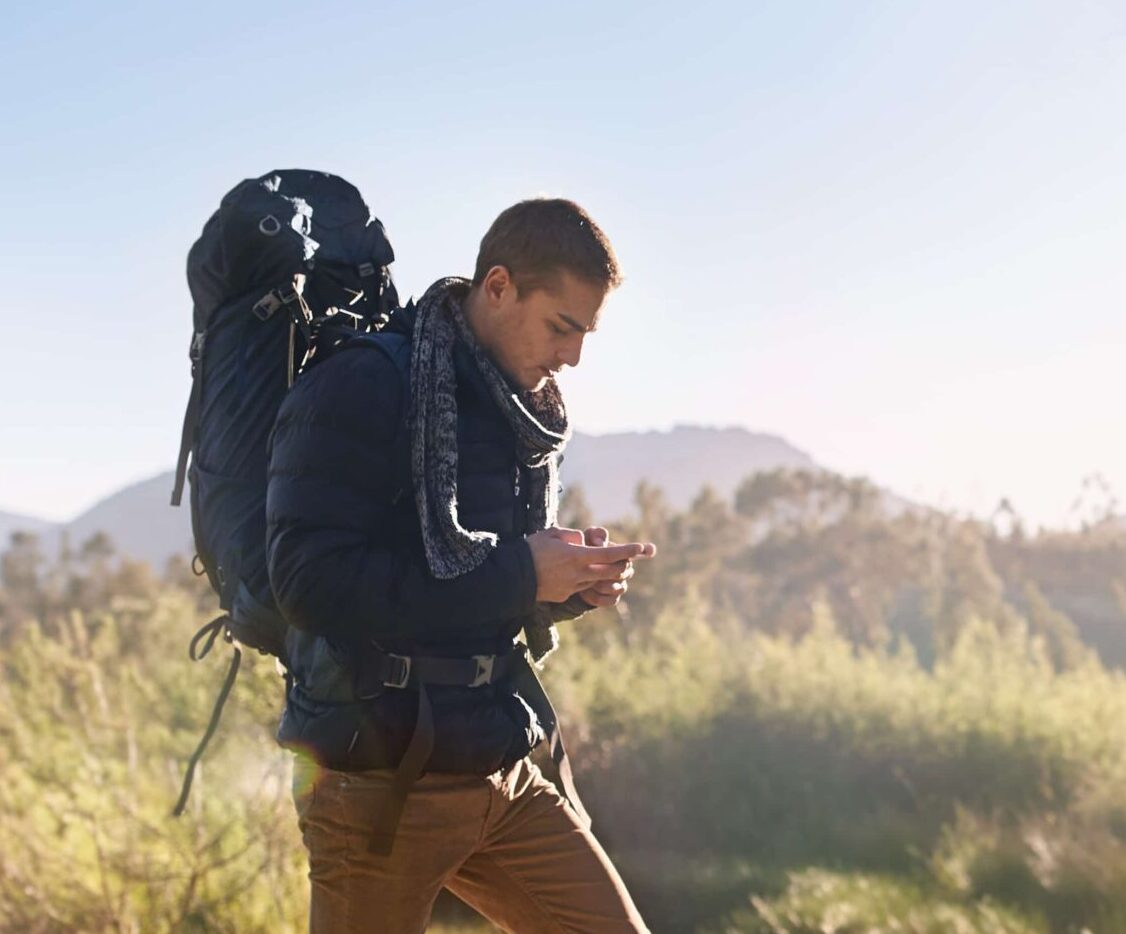 a man with a backpack looking at his phone